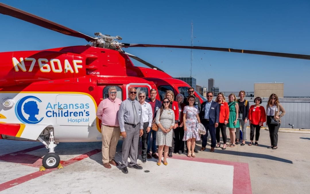 College of Education and Health Professions WE CARE-A-VAN team at Arkansas Children's, standing in front of transport helicopter Angel One.